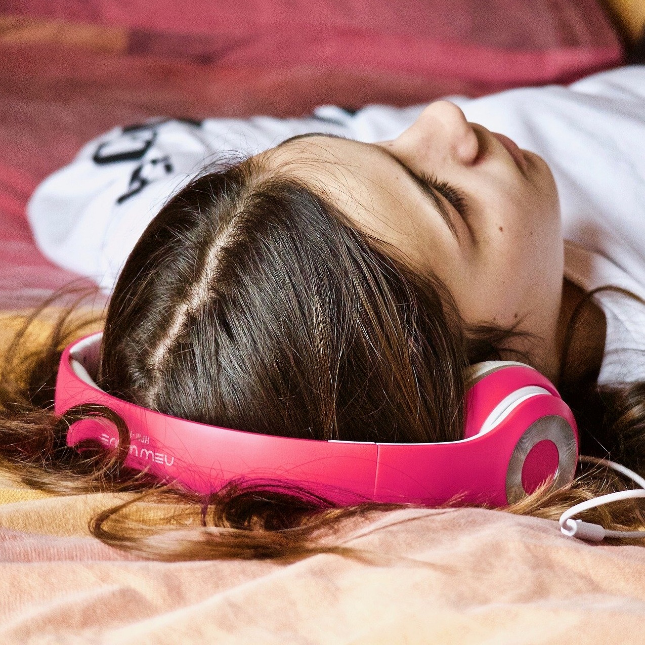 jeune fille allongée en train d'écouter dans un casque