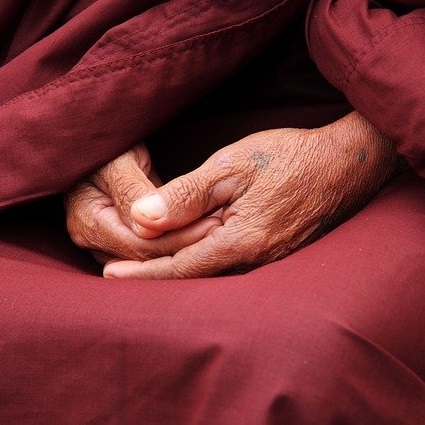 gros plan sur les mains d'une moine bouddhiste
