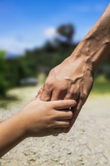 main d'un enfant tenant la main d'un adulte